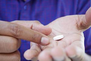 Cerca de la mano del hombre sosteniendo pastillas con espacio de copia foto