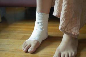 Woman with bandaged foot on bed photo