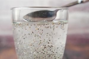 Cerca de semillas de chía en un vaso de agua. foto