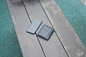 left wallet and smart phone on a bench in the park photo