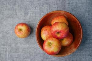Close up of fresh apple in a bowl on wooden table photo