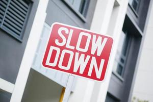 slow down sign against a building photo