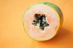 slice of papaya on orange background photo