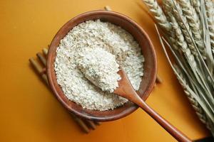 Close up of roasted oats flakes on spoon on table photo