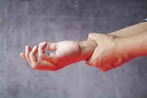 man suffering pain in hand close up photo