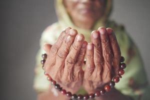 Cerca de la mano de las mujeres mayores orando en Ramadán foto