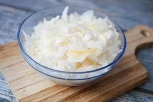 slice of fresh coconut flakes in a bowl on a table photo