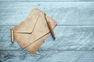 envelope , empty paper and fountain pen on table photo