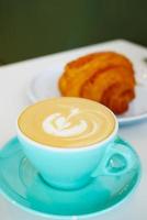 a cup of late coffee with flower shape design on top at cafe photo