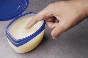 Close up of man hand using petroleum jelly photo