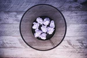 crumpled paper ball in a bin top view photo