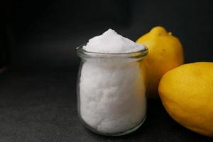 salt and lemon on black background photo