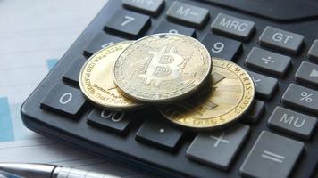 bitcoin et autres cryptocoins sur le dessus de la calculatrice en gros plan video