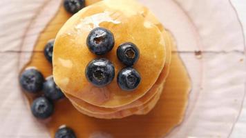 Top view of a pile of pancakes coveres with syrup and blueberries video