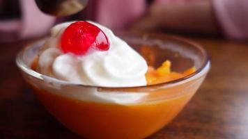 Close up of eating orange dessert with whipped cream and cherry video