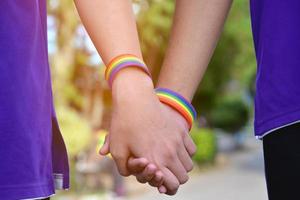 pulsera arcoíris que lleva en la mano un joven gay asiático para mostrar y representar la diversidad de género, respetar los derechos humanos en el sexo alternativo, dejar de castigar a los homosexuales en algunas religiones foto