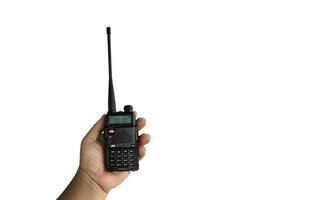 A portable radio transmitter holding in hand, blurred an outdoor building which is constructioning, soft and selective focus. photo