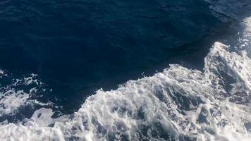 vista superior das belas ondas do mar tropical quente azul natural, manchas na água no oceano, mar, rio, lago. fundo, textura video