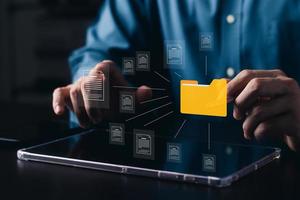 concepto de sistema de gestión de documentos, hombre de negocios con carpeta y software de icono de documento, búsqueda y gestión de archivos en la base de datos de documentos en línea, para un archivo eficiente y datos de la empresa. foto