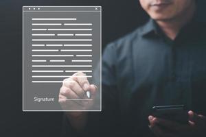 Businessman signature contracts through online documents,the concept of confirmation or approval of the agreement, the application authorization authority, the bank loan documents through support. photo