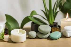 artículos de tratamiento de belleza para procedimientos de spa en una mesa de madera blanca con velas