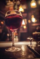 Glass of red wine in a pub with blurred back photo