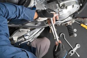 People are repairing a motorcycle Use a wrench and a screwdriver to work photo