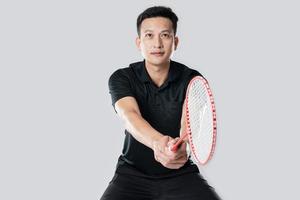 A badminton player in sportswear stands holding a racket and shuttlecock photo