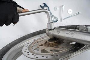 People are repairing a motorcycle Use a wrench and a screwdriver to work photo