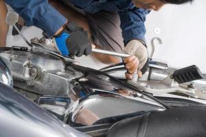 People are repairing a motorcycle Use a wrench and a screwdriver to work photo