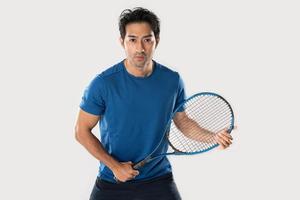 un jugador de tenis masculino sosteniendo una raqueta de tenis con una expresión y ojos determinados. foto