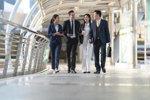 gente de negocios caminando y hablando entre sí frente a la oficina moderna foto