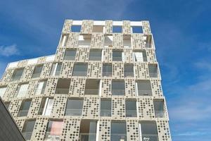 Exterior of modern white openwork house. Architectural detail of close-up on windows and texture wall. Real estate, residential apartment and office. Living apartments or office building architecture. photo