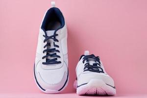 Male sneakers for run on a pink background. White fashion stylish sport shoes photo