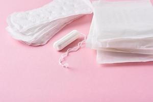 toalla sanitaria y tampón menstrual sobre un fondo rosa foto