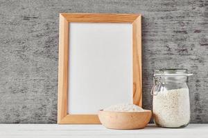 Glass jar with rice and wooden bowl, front view photo