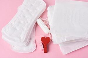toalla sanitaria, tampón menstrual y corazón rojo de madera foto