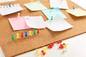 Cork board with a pinned colored blank notes photo