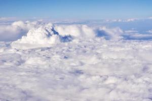 Aerial view of fluffy clouds in a stratosphere from airplane window photo