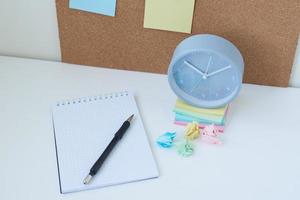 Alarm clock, and cork board with a sticky notes. Home workplace concept photo