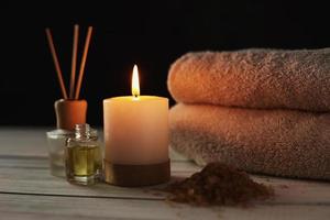 Towels, candle and massage oil on white table photo