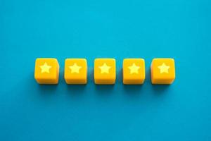 Five stars in a row on yellow blocks. Evaluation of the quality of the provided service. Feedback overview. Popularity, prestige. High reputation. Successful business, satisfied customers. photo