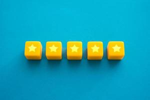 Five stars in a row on yellow blocks. Evaluation of the quality of the provided service. Feedback overview. Popularity, prestige. High reputation. Successful business, satisfied customers. photo