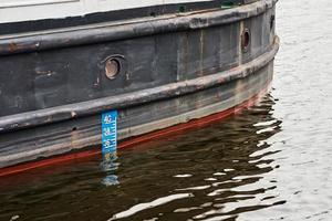 Waterline on hull of cargo ship, closeup photo