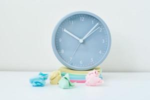 Gray round alarm clock and colorful sticky notes on a white background photo