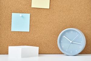 Sticky notes on a cork board and alarm clock in workplace office or home photo