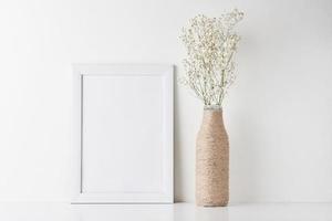 Workspace desk with empty frame and flower in vase photo