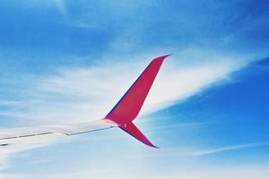 airplane wing andblue sky with clouds, view from the airplane window photo