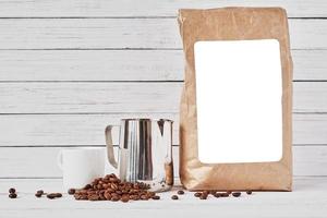 Coffee cup, craft paper bag and stainless pitcher photo