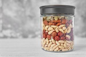 Different types of nuts and seeds in a glass jar close up photo